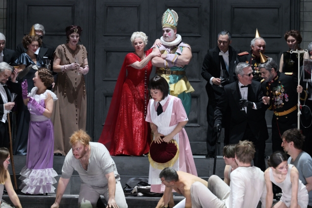 vorne in der Bildmitte Nicholas Brownlee (Amonasro), Guanqun Yu (Aida), dahinter Claudia Mahnke (Amneris; in rotem Kleid), Ensemble